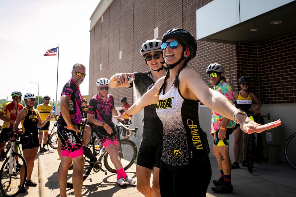 Andrea Parrott decorates fellow riders with some glitter spray during the RAGBRAI route inspection ride Friday in Belle Plaine.