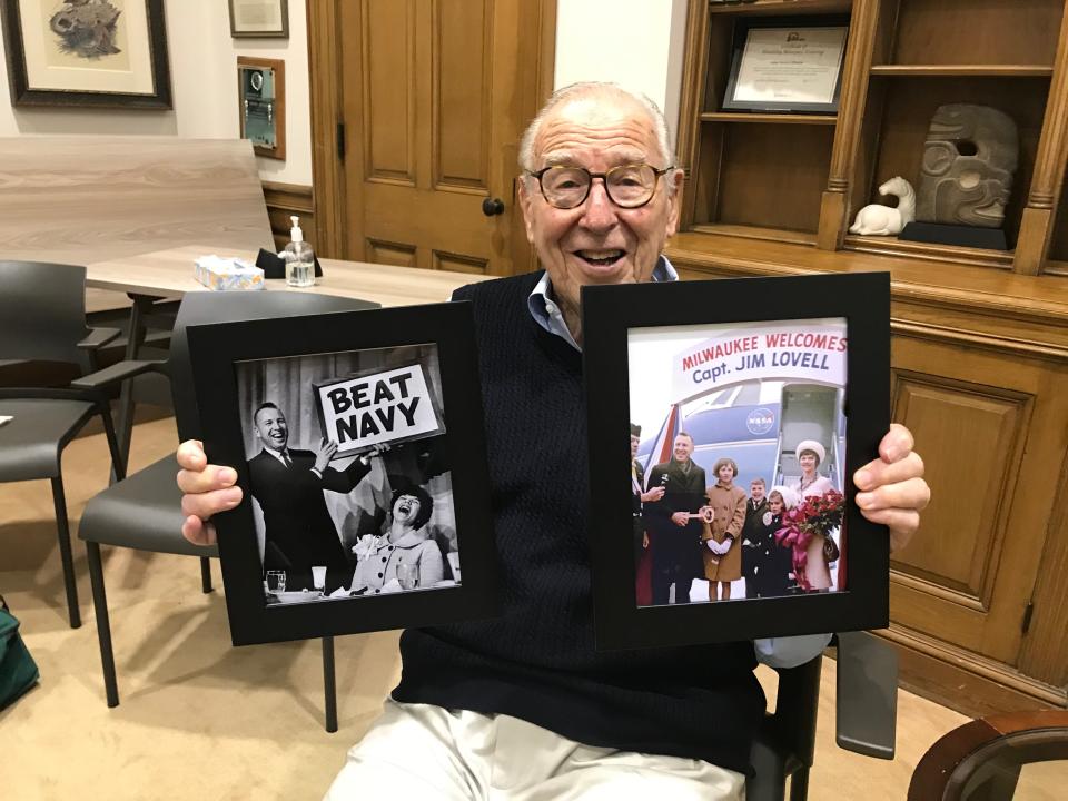 Jim Lovell holds two framed Milwaukee Journal photos from his 1965 return to his hometown with his family after flying in Gemini 7.