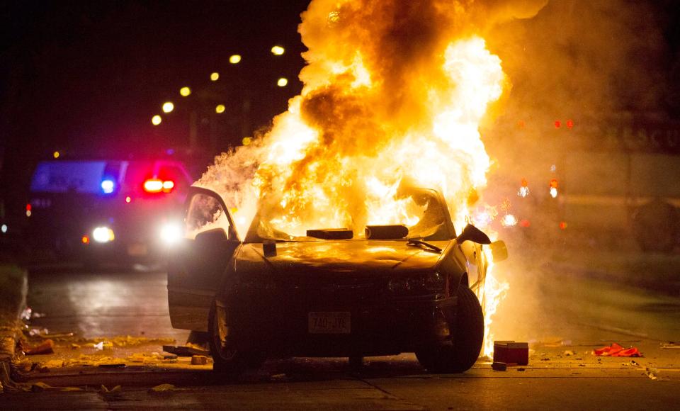 A car burns at the scene of a disturbance at Sherman Blvd. and Auer Ave. Saturday night in Milwaukee.