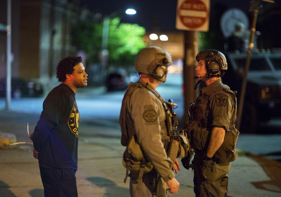 A man at left who would not give his name is arrested for violating the curfew where Monday's riots occurred following the funeral for Freddie Gray, Tuesday, April 28, 2015, in Baltimore. (AP Photo/David Goldman)