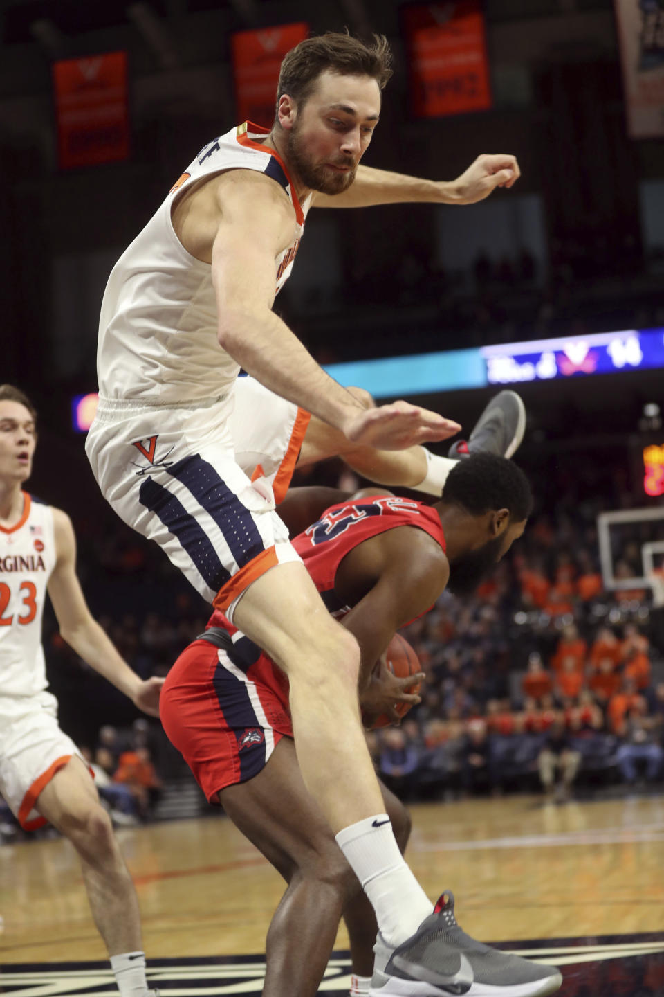 Virginia forward Jay Huff leaps over Stony Brook guard Andrew Garcia (23) during an NCAA college basketball game in Charlottesville, Va., Wednesday, Dec. 18, 2019. (AP Photo/Andrew Shurtleff)