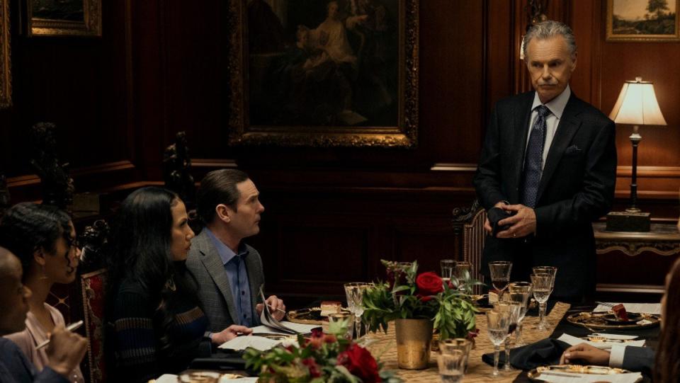 Frederick Usher wears a blue suit at a dinner table in fall of house of usher