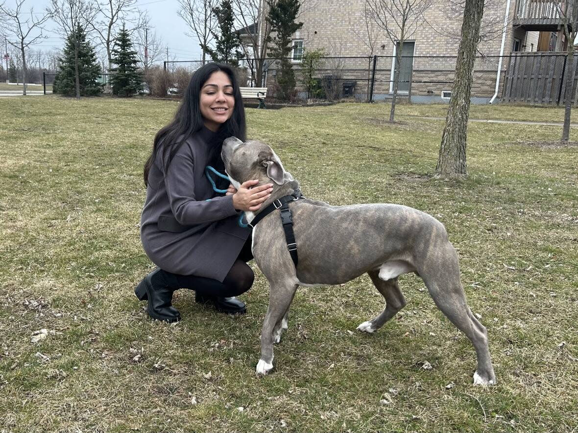 Aliesha Verma walks with the dog, Rocco Junior, that is at the centre of her legal battle with the estate of her late boyfriend. She maintains Rocco was a gift and is needed as a support animal, but an Ontario judge ruled last month the dog belongs to his estate.   (Mike Smee/CBC - image credit)