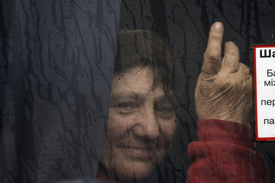 A woman evacuated from the town of Shevchenkove by the Ukrainian government due to heavy fighting against Russia, waits inside a bus upon arrival in Brovary, on the outskirts of Kyiv, Ukraine, Tuesday, March 29, 2022. (AP Photo/Rodrigo Abd)