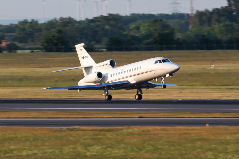Private jet landing on a runway with landing gear deployed