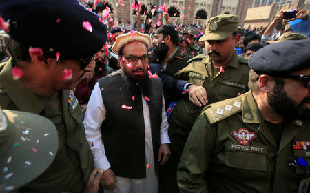 Hafiz Saeed is showered with flower petals as he walks to court before a Pakistani court ordered his release from house arrest in Lahore, Pakistan November 22, 2017. REUTERS/Mohsin Raza