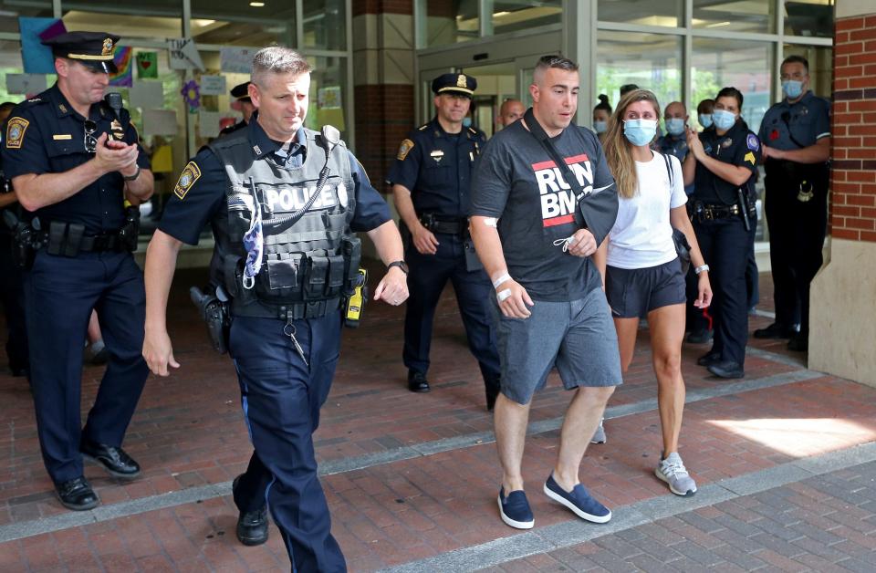 Braintree police officer Matthew Donoghue leaves Boston Medical Center with his wife to the applause of fellow officers on June 5, 2021.