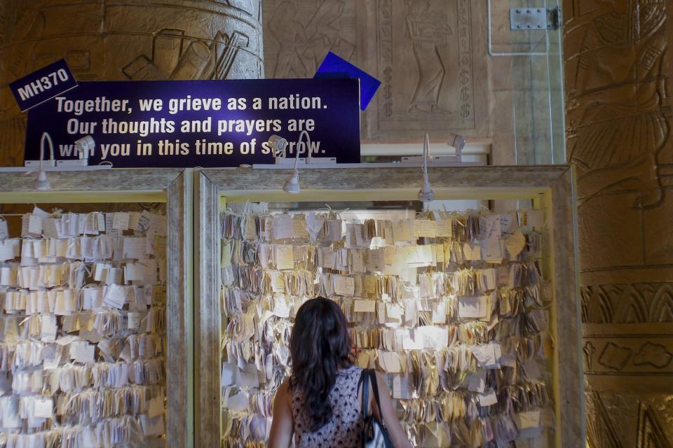 A woman looks at support messages for the relatives of the passengers onboard missing Malaysia Airlines Flight MH370 inside a shopping mall in Petaling Jaya, near Kuala Lumpur