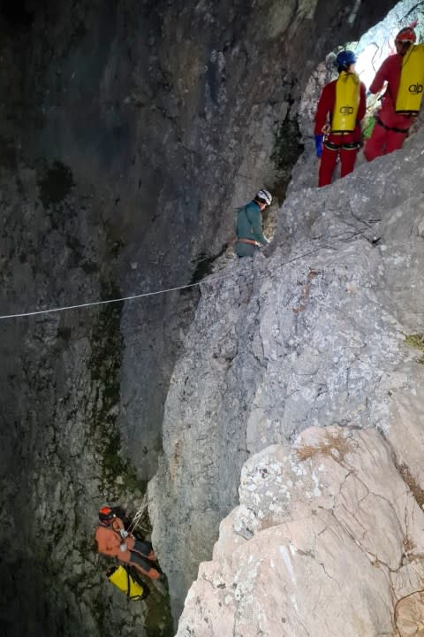 Members of the CNSAS, Italian alpine and speleological rescuers, start to descent on ropes the Morca cave during a rescue operation near Anamur, south Turkey, Monday, Sept. 11, 2023. A rescue operation is underway in Turkey’s Taurus Mountains to bring out an American researcher who fell seriously ill at a depth of some 1,000 meters (3,000 feet) from the entrance of one of world’s deepest caves last week and was unable to climb out himself. Mark Dickey is being assisted by international rescuers who by Monday had brought him up to 300 meters (nearly 1,000 feet). (CNSAS Via AP)