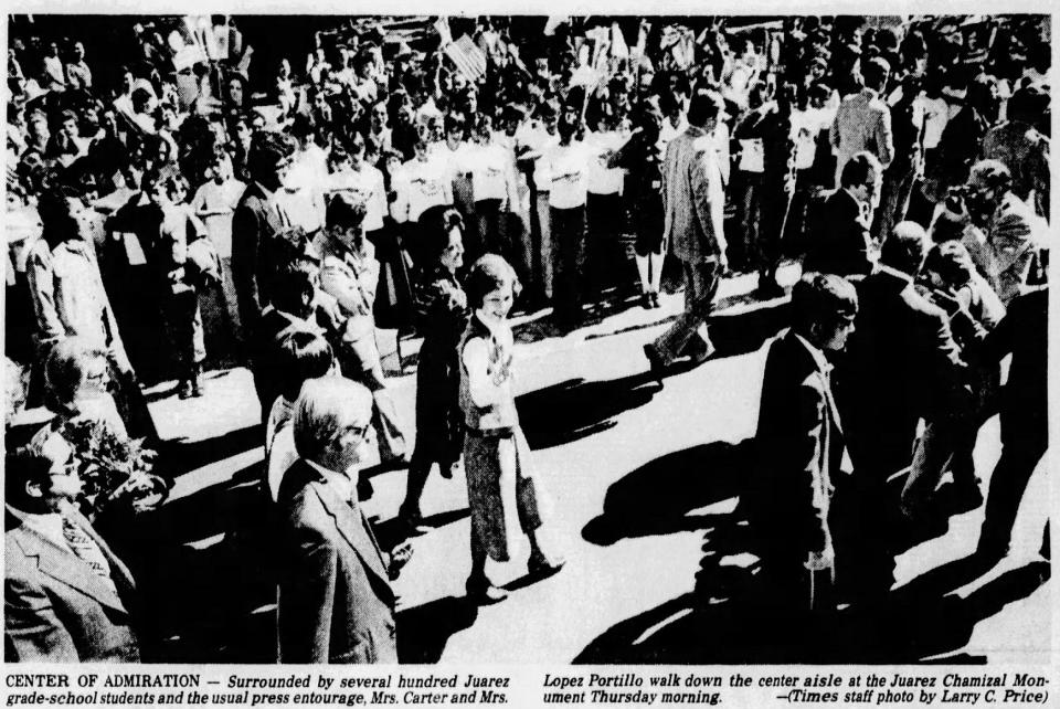 Surrounded by several hundred Juárez grade-school students and the usual press entourage, Mrs. Carter and Mrs. Lopez Portillo walk down the center aisle at the Juárez Chamizal Monument Nov. 3, 1977.
