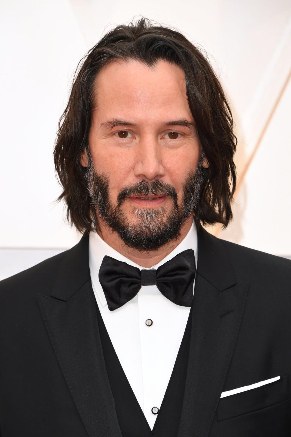 Gray beard, long hair, and black tie