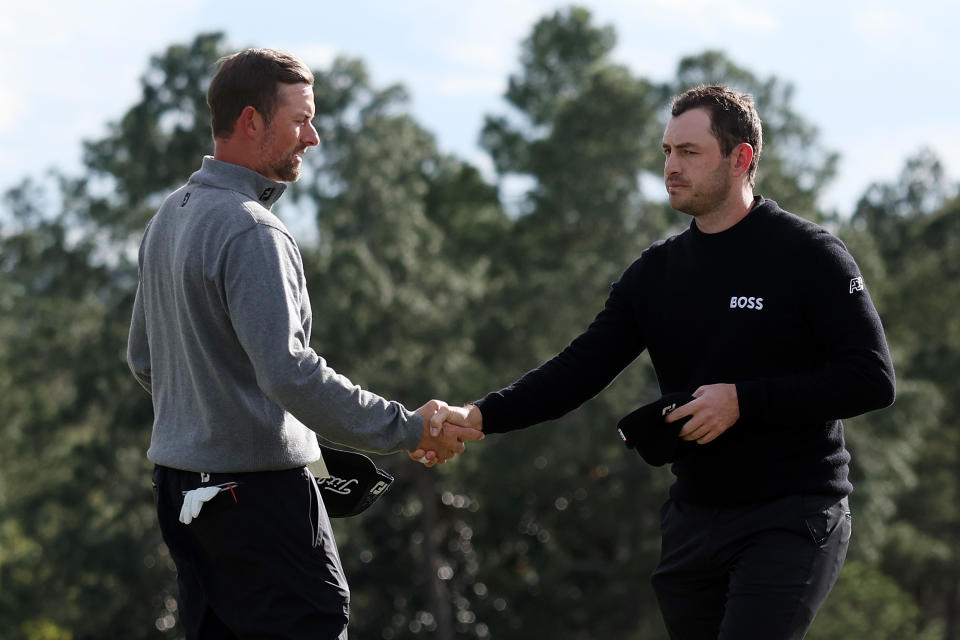 Webb Simpson (L) and Patrick Cantlay shake hands on the 18th green after finishing their round during the third round of the Masters at Augusta National Golf Club on April 09, 2022 in Augusta, Georgia. (Photo by Gregory Shamus/Getty Images)
