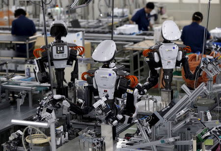 Humanoid robots work side by side with employees on the assembly line at a factory of Glory Ltd., a manufacturer of automatic change dispensers, in Kazo, north of Tokyo, Japan, in this July 1, 2015 file photo. REUTERS/Issei Kato/Files