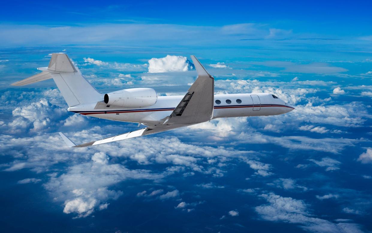 Private jet cruising above the clouds - Alamy Stock Photo