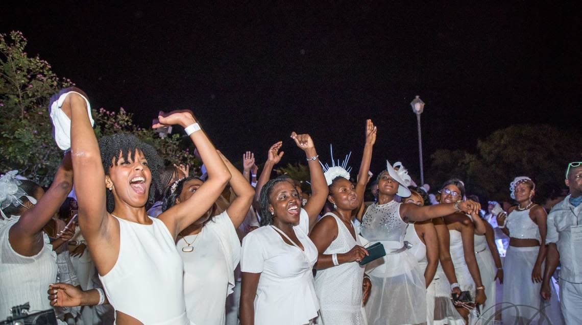 People cheering during the Dîner en Blanc Haiti in Cap Haitien in 2019.