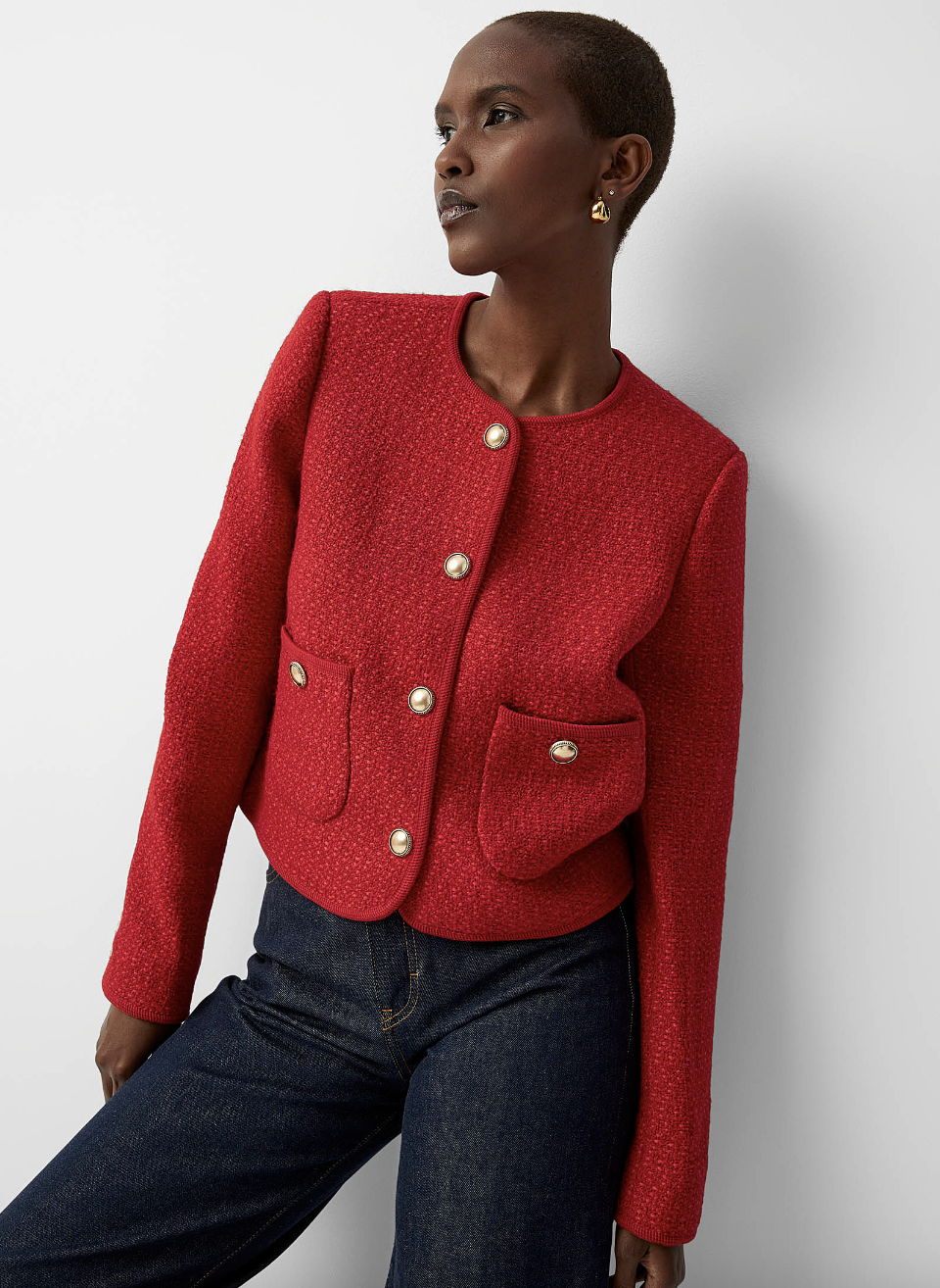 black model with short hair wearing dark jeans and Contemporaine Cropped Bright Tweed Blazer in Red (Photo via Simons)