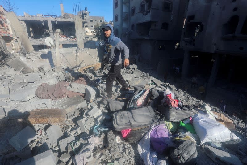 Palestinians inspect the site of an Israeli strike on a residential building, at Nuseirat refugee camp in central Gaza Strip