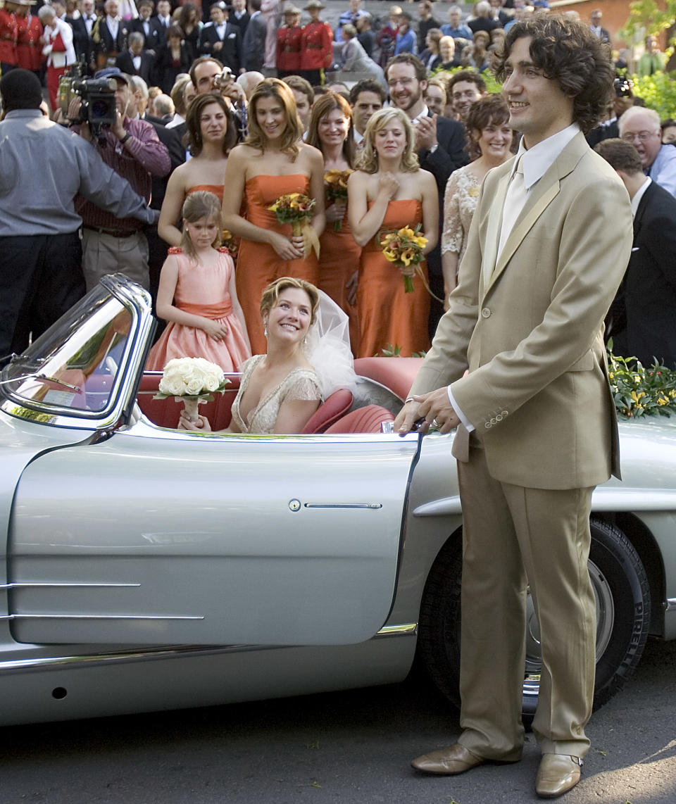 Sophie Gregoire looks up at her new husband Justin Trudeau, son of the late Prime Minister Pierre Elliot Trudeau as he gets into his father's 1959 Mercedes 300SL following their wedding nuptials in Montreal, May 28, 2005. REUTERS/Christinne Muschi   CM