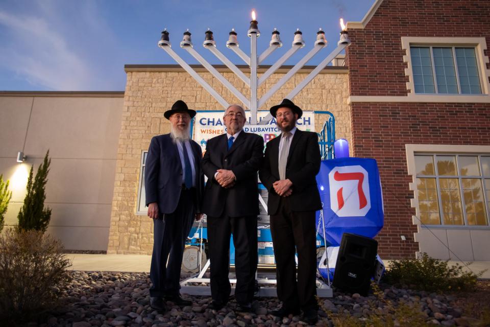 From left, Rabbi Yisrael Greenberg, City Representative Brian Kennedy, and Rabbi Levi Greenberg pose in front of a public menorah after the first candle was lit to begin Hanukkah on Dec.7, 2023.