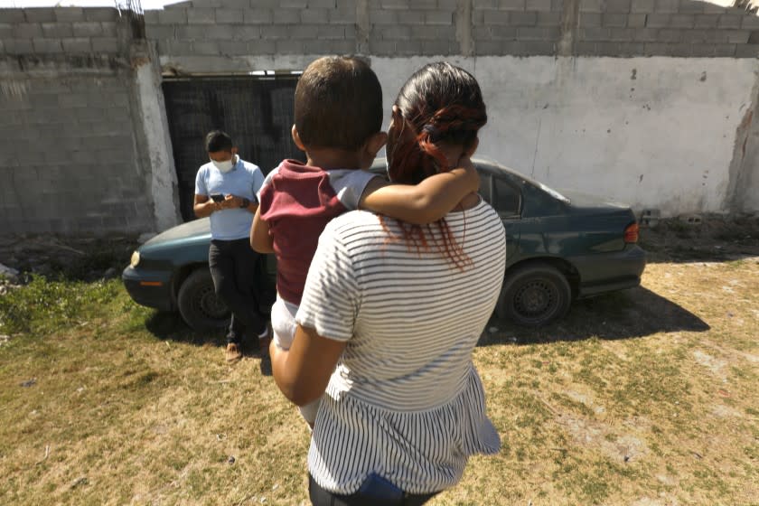 iMATAMOROS, MEXICO—"Why are we in limbo?" said Denis, left, an asylum seeker in Matamoros. Denis, 29, lives at a shelter with his wife, Yuri, right, and 2 year-old son Mykal, middle, who has developmental delays. Two years ago, the cell phone accessory salesman fled north with his wife and three children, was refused asylum in January 2020 and sent his two eldest - Daniela, 10, and Naomi, 6 - across the border bridge to stay with relatives in Roanoke, Va. Many families seeking asylum in the United States are stuck in Mexico under the "remain in Mexico" program put into effect under the Trump administration.Photo taken on March 19, 2021 in Matamoros, Mexico. (Carolyn Cole / Los Angeles Times)