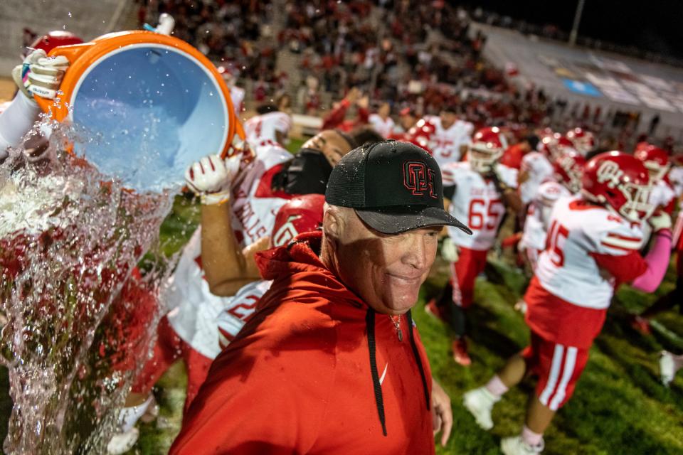 Oak Hills players pour water on head coach Robert Metzger after beating Apple Valley 41-27 on Friday, Oct. 21, 2022.