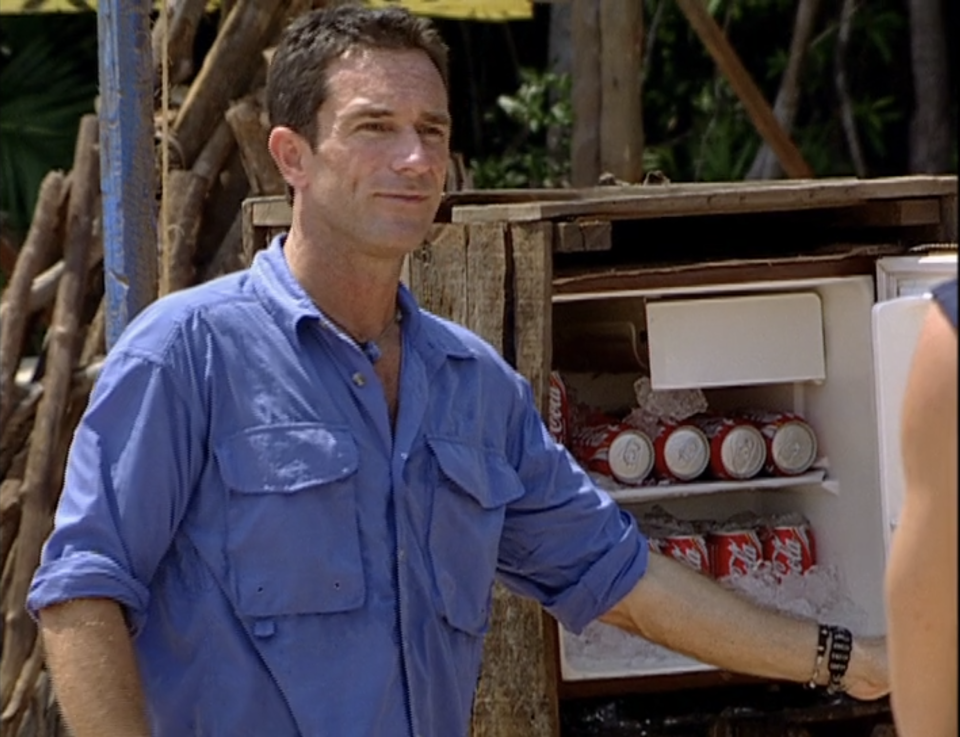 Jeff Probst stands next to a wodden fridge filled with Coke