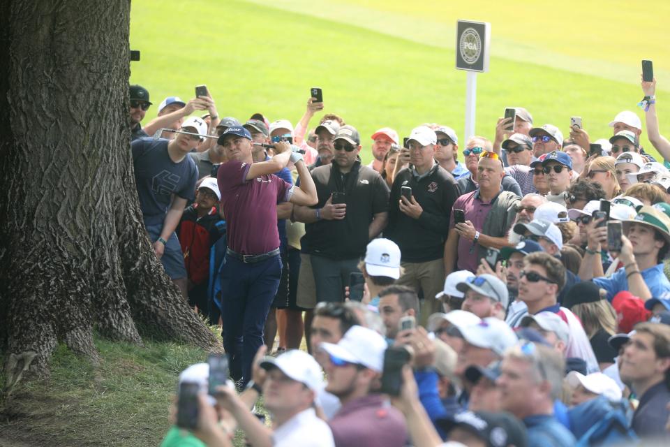 Phones go up to take photos of Justin Thomas as he hits his ball up onto the green on 13, close to the hole.  His ball  that landed here, was closer to the fairway on 1 than the intended 13th fairway.