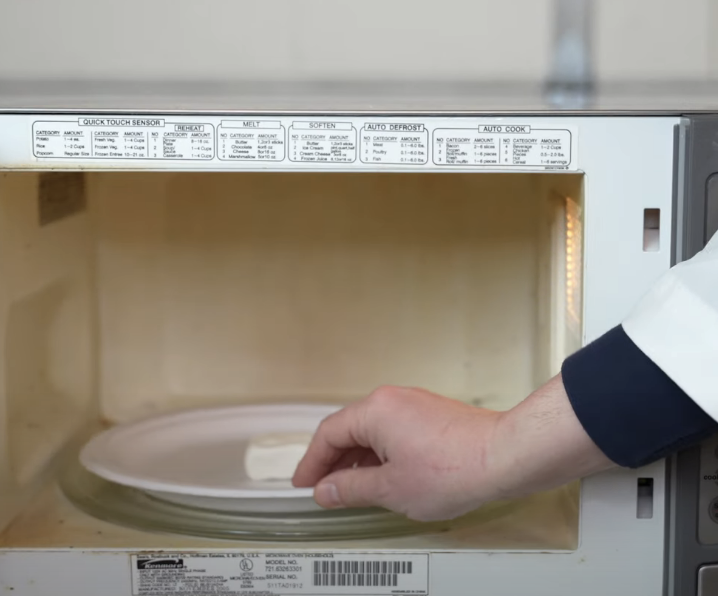 putting a plate with a marshmallow on it in the microwave