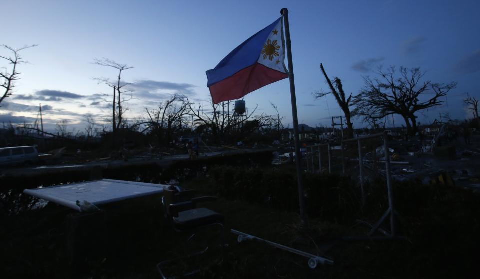 A Philippine flag flutters outside a damaged airport after super Typhoon Haiyan battered Tacloban city in central Philippines November 9, 2013. Possibly the strongest typhoon ever to hit land devastated the central Philippine city of Tacloban, killing at least 100 people, turning houses into rubble and leveling the airport in a surge of flood water and high wind, officials said on Saturday. The toll of death and damage from Typhoon Haiyan on Friday is expected to rise sharply as rescue workers and soldiers reach areas cut off by the massive, fast-moving storm which weakened to a category 4 on Saturday. REUTERS/Erik De Castro (PHILIPPINES - Tags: DISASTER ENVIRONMENT)