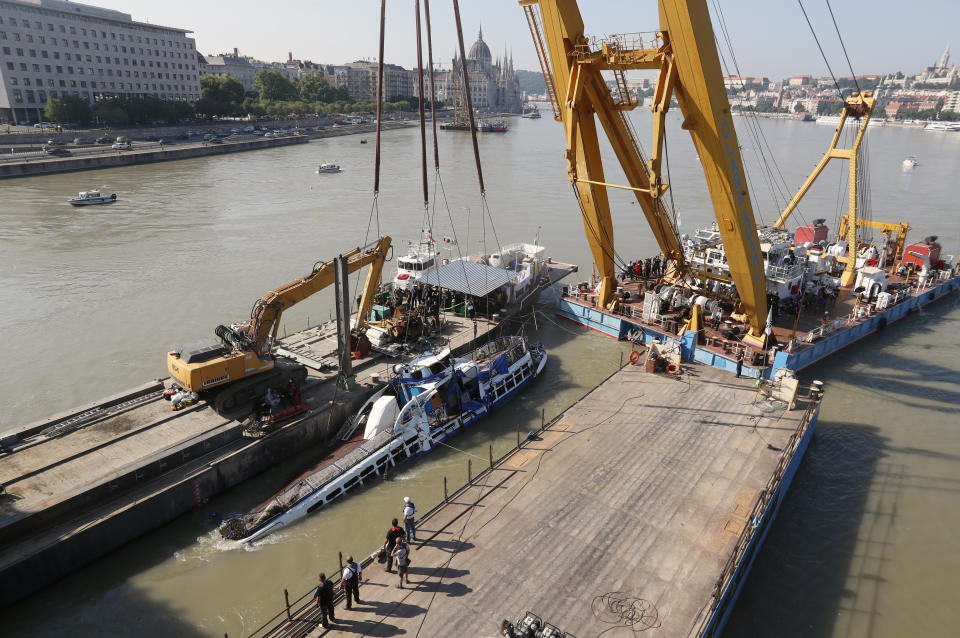 A crane lifts the sightseeing boat out of the Danube river in Budapest, Hungary, Tuesday, June 11, 2019. Eight people are still missing from the May 29 collision between the Hableany (Mermaid) sightseeing boat and the Viking Sigyn river cruise ship at Budapest's Margit Bridge. (AP Photo/Darko Bandic)