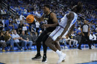 Colorado forward Evan Battey (21) fouls UCLA forward Kenneth Nwuba (14) during the first half of an NCAA college basketball game in Los Angeles, Wednesday, Dec. 1, 2021. (AP Photo/Ashley Landis)