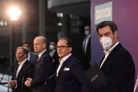 From left, the chairman of the German Christian Democratic Party (CDU), Armin Laschet, parliamentary group leader of the conservative CDU/CSU union, Ralph Brinkhaus, Christian Social Union (CSU) parliamentary group leader Alexander Dobrindt and the chairman of the German Christian Social Union (CSU) Markus Soeder after a statement following a closed meeting of the federal parliament factions of both parties in Berlin, Germany, Sunday, April 11, 2021. The two party chairmen and German state governors want to become the center-right candidate for the country's Sept. 26 national election, the German news agency dpa reported Sunday. (Tobias Schwarz/Pool Photo via AP)