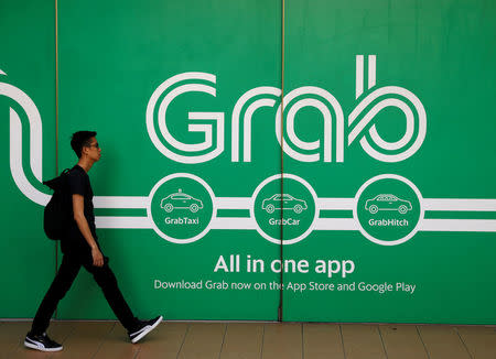 FILE PHOTO: A man walks past a Grab office in Singapore March 26, 2018. REUTERS/Edgar Su/File Photo