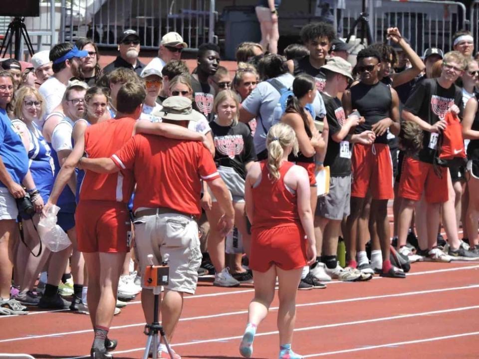 BNL Unified Track & Field head coach Mike Branam (middle) walks an injured Tanner Robbins (left) and Jesselyn Fisher (right) out to receive their Mental Attitude Awards at Saturday's IHSAA State Finals.