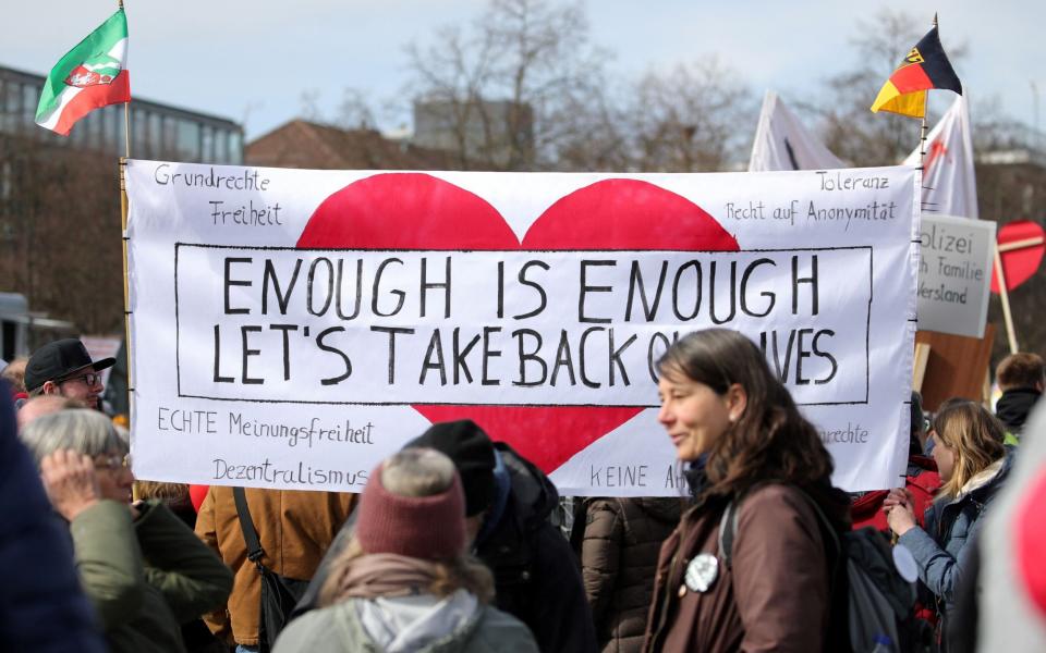 Protestors hold up a banner reading 'Enough is enough - let's take back our lives' - ARMANDO BABANI/ AFP