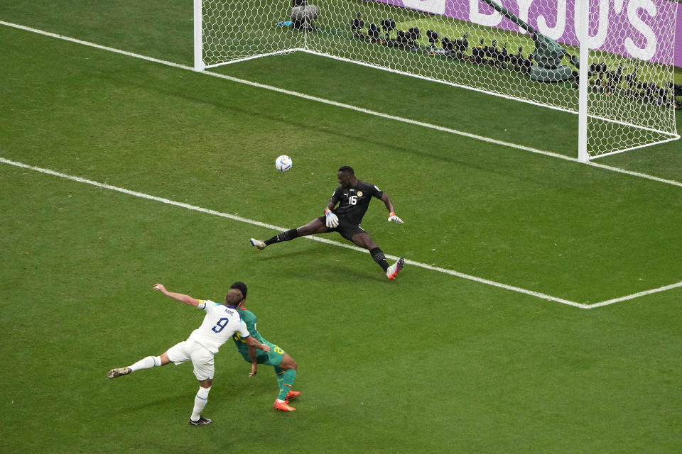 England's Harry Kane, left, scores his side's 2nd goal during the World Cup round of 16 soccer match between England and Senegal, at the Al Bayt Stadium in Al Khor, Qatar, Sunday, Dec. 4, 2022. (AP Photo/Ariel Schalit)