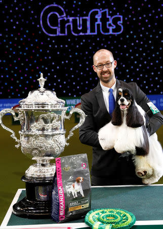 American Cocker Spaniel Miami poses with its handler Jason Lynn after being awarded best in show during the final day of the Crufts Dog Show in Birmingham, Britain March 12, 2017. REUTERS/Darren Staples