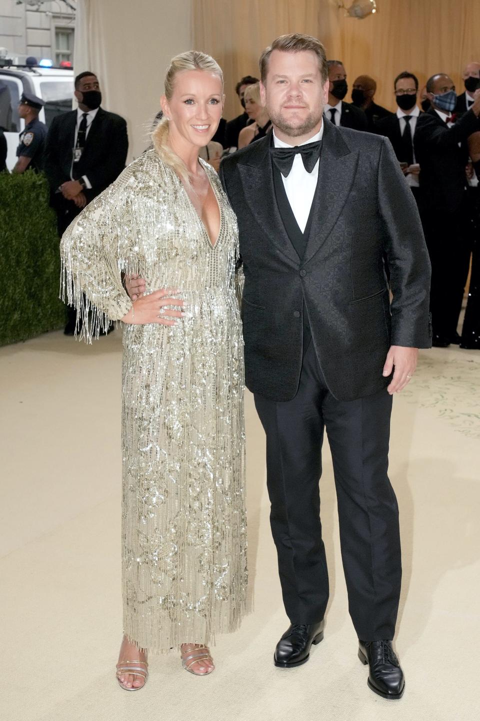 Julia Carey and James Corden stand on a red carpet.