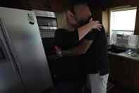 Mike Gilpatrick, who as a teenager was incarcerated at the Youth Development Center, kisses his wife Kelly, who as stood with him over their 16 years of marriage, prior her picking up their son at school at their home, Wednesday, Sept. 8, 2021, in Nashua, N.H. Gilpatrick, 38, filed a lawsuit Monday Sept. 13, alleging he was physically and sexually abused at the former YDC in Manchester, which has been the target of a criminal investigation since 2019 and is slated to close in 2023. (AP Photo/Charles Krupa)