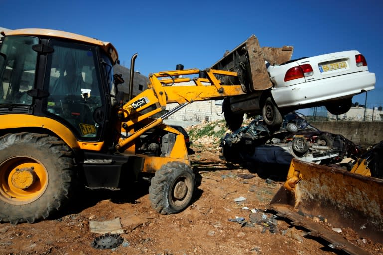 A bulldozer smashes a car as part of efforts to combat an underground market for vehicles stolen in Israel or deemed not roadworthy transported into the occupied West Bank