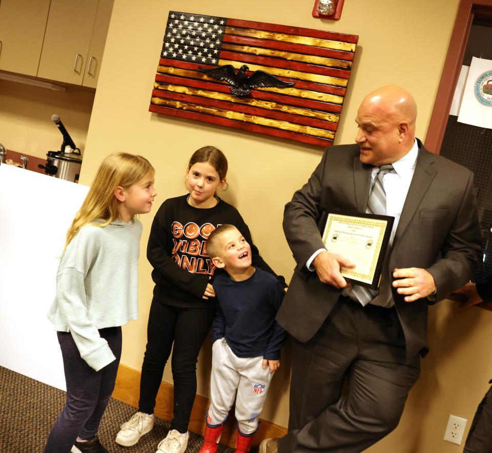 Selectmen presented the "Raynham Recognition Award" to Police Det. Louis F. Pacheco, right, with his grandchildren Allison Leone, 8, Ava Leone, 6, and Cohen Leone, 4, at Town Hall on Tuesday, Jan. 23, 2024.