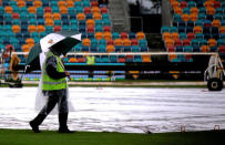 Cricket - Australia v South Africa - Second Test cricket match - Bellerive Oval, Hobart, Australia - 13/11/16 A security guard holds an umbrella while walking around the covered pitch as rain falls during the second day of the second test between Australia and South Africa. REUTERS/David Gray