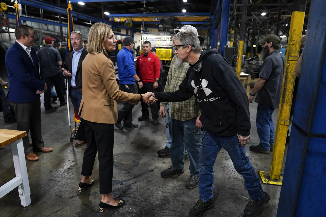 Iowa Gov. Kim Reynolds greets employees after speaking at a news conference at Iowa Spring Manufacturing, Wednesday, Oct. 20, 2021, in Adel, Iowa. (AP Photo/Charlie Neibergall)
