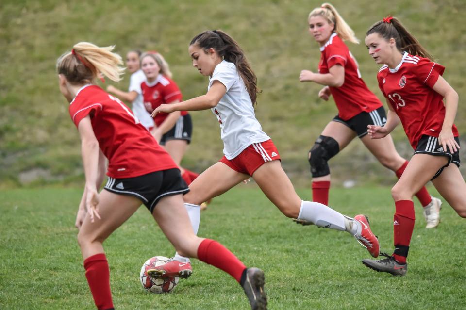 Rutland's Bethany Solari races past CVU's Riley Erdman during their semifinal match vs the Redhawks on Tuesday afternoon in Hinesburg.