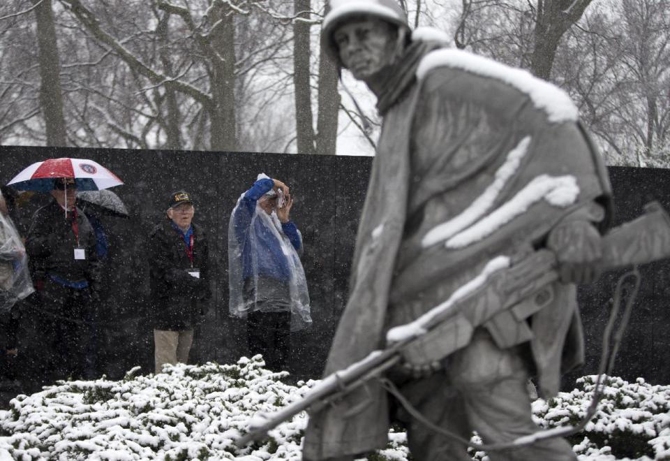 Visitors view the Korean War Memorial during a snow storm in Washington, Tuesday, March 25, 2014. The calendar may say it's spring, but the mid-Atlantic region is seeing snow again. The National Weather Service has issued a winter weather advisories for much of the region Tuesday. The advisories warn that periods of snow could make travel difficult, with slippery roads and reduced visibility. (AP Photo/ Evan Vucci)