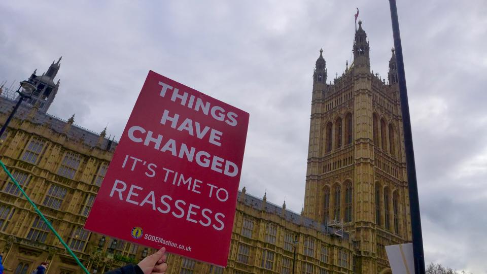 An anti-Brexit activist holds placards at the media centre outside the Houses of Parliament, London on December 12, 2018. Photo: NurPhoto for Getty