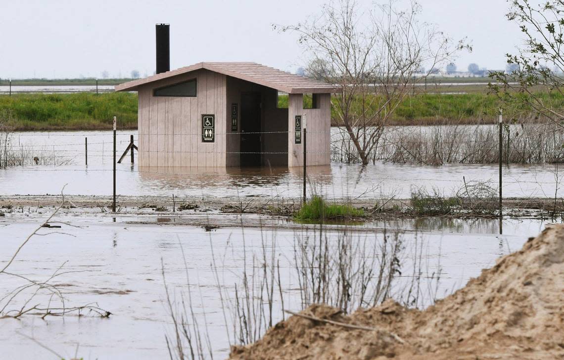 A restroom facility is flooded at the Pixley National Wildlife Refuge by swollen Deer Creek, foreground, Saturday afternoon, March 18, 2023.