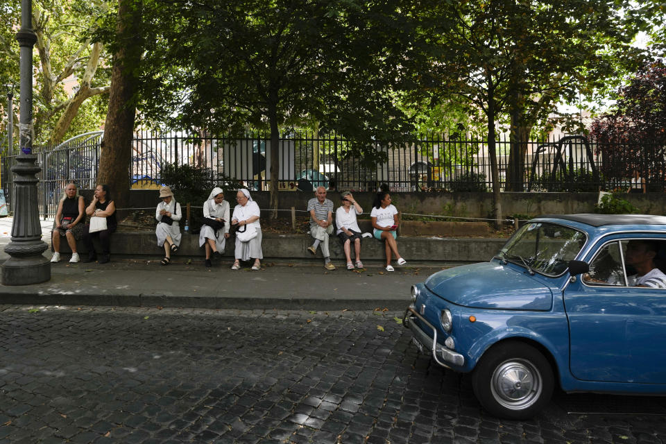 People sit in the shade in downtown Rome, Thursday, July 13, 2023. An intense heat wave has reached Italy, bringing temperatures close to 40 degrees Celsius in many cities across the country.(AP Photo/Alessandra Tarantino)