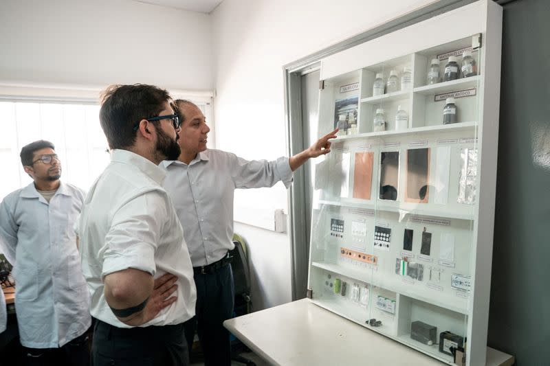 FILE PHOTO: Chile's President Gabriel Boric looks to lithium samples and applications in the northern city of Antofagasta, Chile