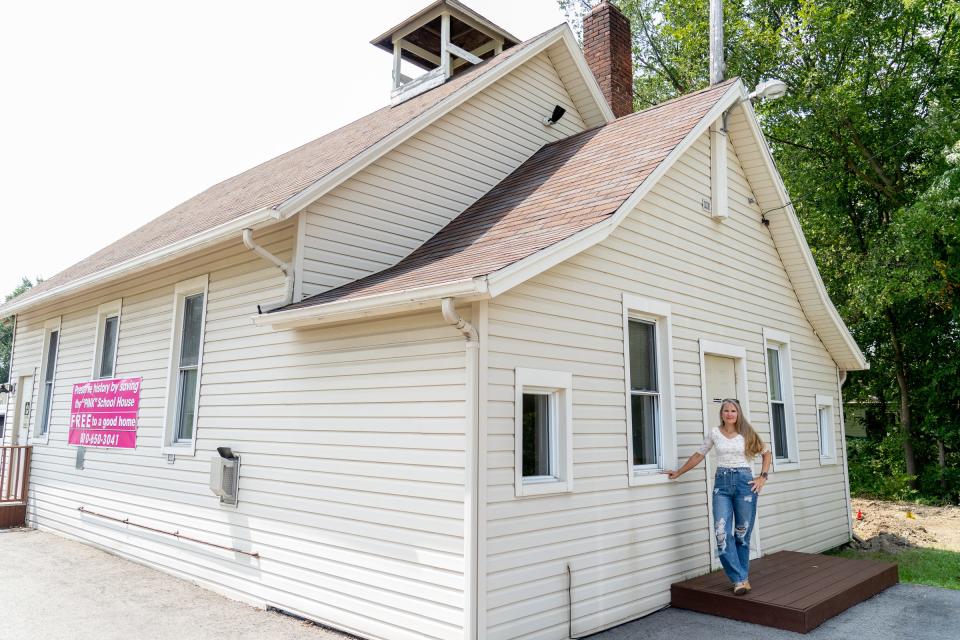 Wendy Greer, of St. Clair Township, stands outside the former Pink School House in Columbus Township, Mich., where her grandmother Freeda Cody-Dewey once taught.